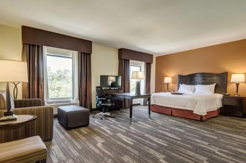 a hotel room with a bed and a desk at Hampton Inn Poplar Bluff in Poplar Bluff
