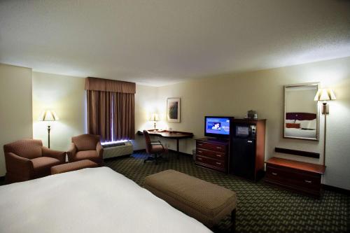 a hotel room with a bed a desk and a television at Hampton Inn Carrollton in Carrollton