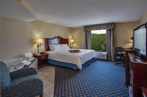 um quarto de hotel com uma cama e uma banheira e uma televisão em Hampton Inn Clearfield em Clearfield