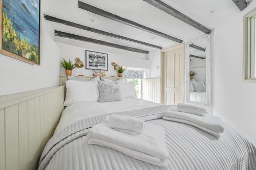 a bedroom with a large bed with towels on it at Luxury Couple's Getaway with River Views and Parking in Polperro