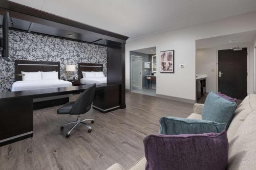a hotel room with a bed and a desk and chairs at Hampton Inn & Suites Chattanooga Downtown in Chattanooga