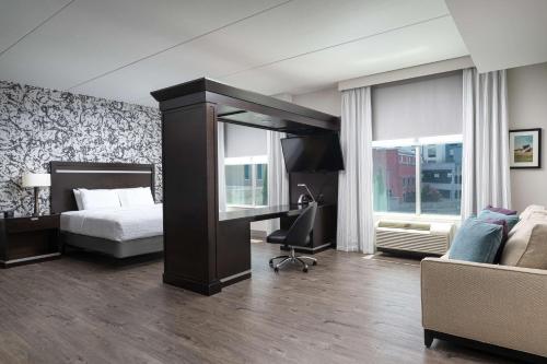 a bedroom with a bed and a desk and a couch at Hampton Inn & Suites Chattanooga Downtown in Chattanooga