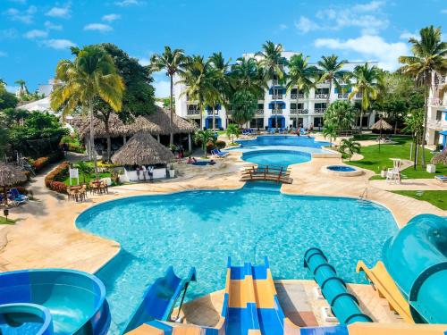 普拉亞布蘭卡的住宿－普拉亞布蘭卡海灘全包度假酒店，一个带滑梯和椅子以及棕榈树的度假游泳池