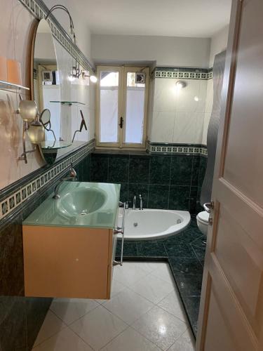La salle de bains est pourvue d'un lavabo, d'une baignoire et de toilettes. dans l'établissement Silver appartament Oceania, à Envie