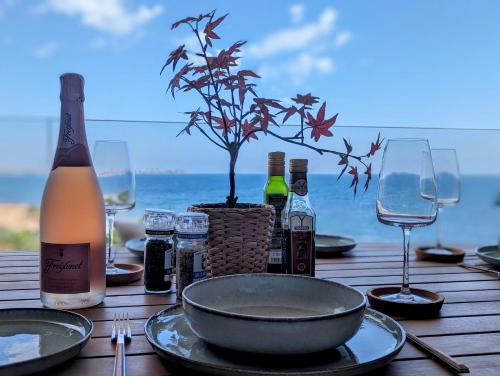 a table with a bottle of wine and a tree on it at Apartment Posidonia Punta Prima in Orihuela