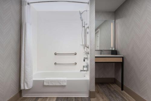 a bathroom with a bath tub and a sink at Hilton Garden Inn Chattanooga Downtown in Chattanooga