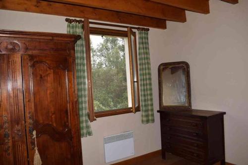 Cette chambre dispose d'une fenêtre, d'une commode et d'un miroir. dans l'établissement Romantique, avec son petit étang privé en Dordogne, à Montignac