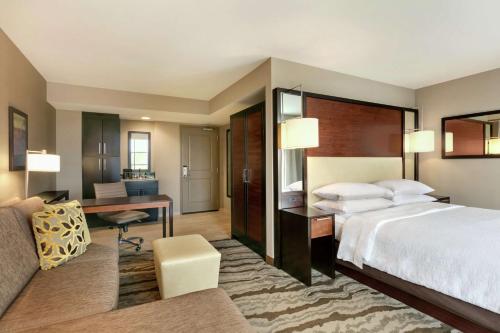 チャタヌーガにあるEmbassy Suites Chattanooga Hamilton Placeのベッドとデスクが備わるホテルルームです。