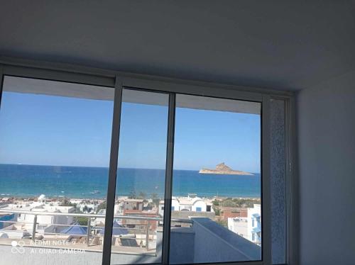 a view of the ocean from a room with two windows at Basma in Rafrāf