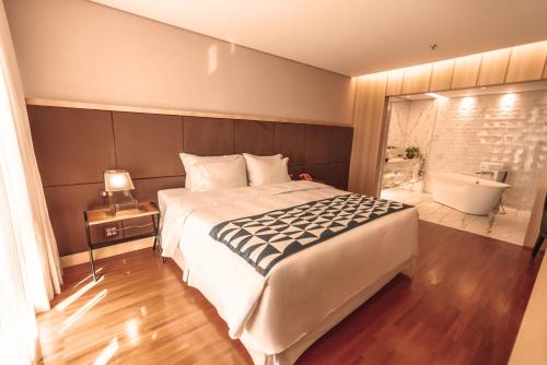 a bedroom with a large bed and a bath tub at Brasília Palace Hotel in Brasilia