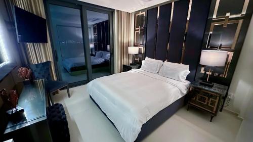 a bedroom with a large white bed and a mirror at Mullet Bay Suites - Your Luxury Stay Awaits in Cupecoy