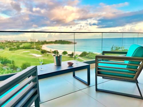 a balcony with a table and a chair and the ocean at Mullet Bay Suites - Your Luxury Stay Awaits in Cupecoy