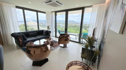 a living room with a couch and chairs and windows at Mullet Bay Suites - Your Luxury Stay Awaits in Cupecoy