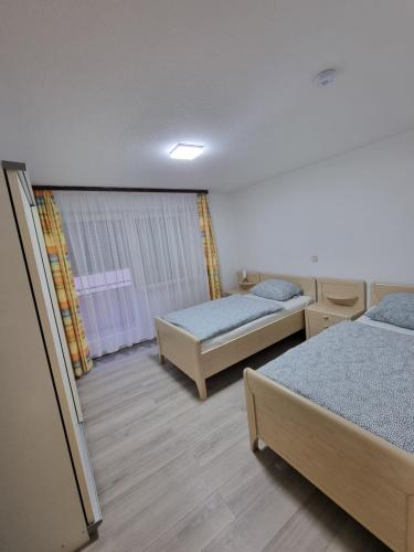 1 dormitorio con 2 camas y ventana en Ferienwohnung Safi en Sachsenheim