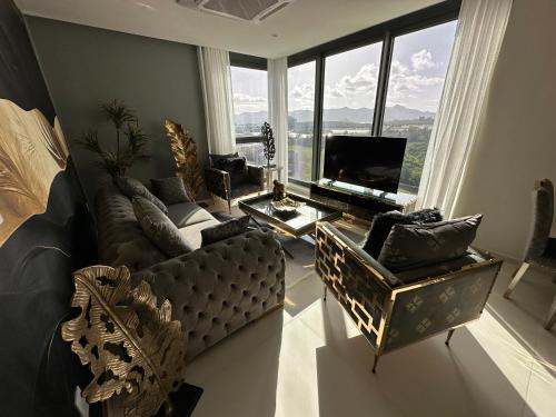 a living room with a couch and a large window at Mullet Bay Suites - Your Luxury Stay Awaits in Cupecoy