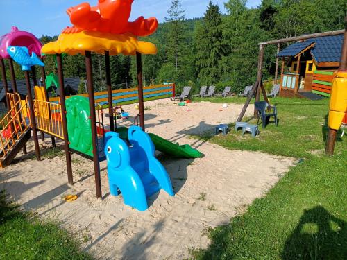un parque infantil con equipo de juegos en la arena en uDany Noclegi ze Śniadaniem, en Szczyrk