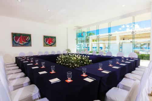 a long table in a room with white chairs at Krystal Cancun in Cancún