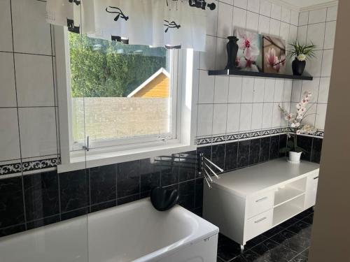 łazienka z wanną, umywalką i oknem w obiekcie Hus med utsikt over Alta elva w Alcie