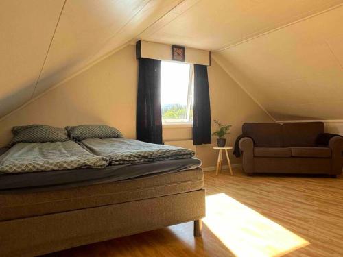 sypialnia z łóżkiem i kanapą na poddaszu w obiekcie Hus med utsikt over Alta elva w Alcie
