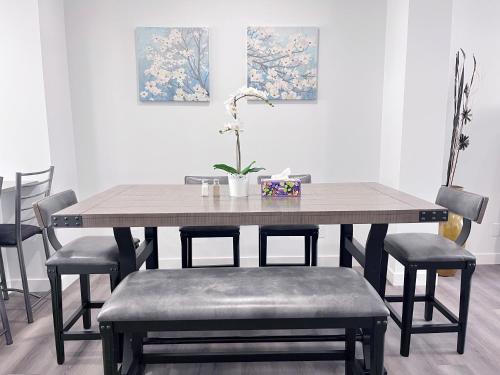 a dining room table with chairs and a potted plant at Private Entire Townhouse Retreat Close to Lake in Calgary