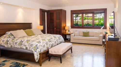 ein Schlafzimmer mit einem Bett, einem Stuhl und einem Sofa in der Unterkunft Sunny Vacation Villa No 84 in San Rafael del Yuma