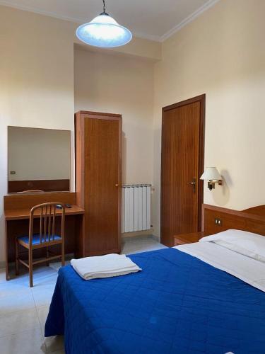 a bedroom with a blue bed and a desk at Guest House Pitagora in Rome