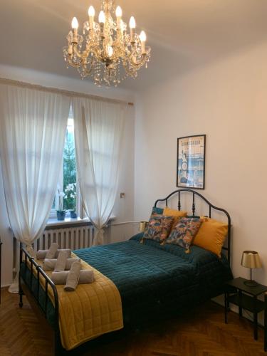 Warsaw Mermaid Apartment - Ideal place for You في وارسو: غرفة نوم بسرير مع ثريا