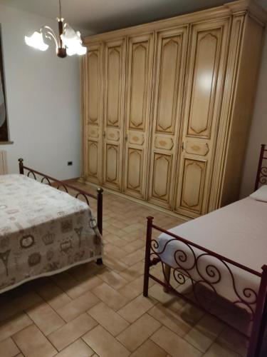 een slaapkamer met 2 bedden en houten kasten bij Appartamento ALBA locazione turistica in Spoleto
