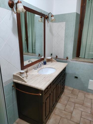 een badkamer met een wastafel en een spiegel bij Appartamento ALBA locazione turistica in Spoleto