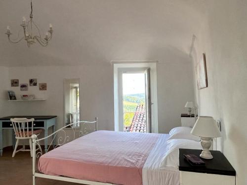 um quarto com uma cama, uma secretária e uma janela em La Casetta di Treville em Ozzano Monferrato