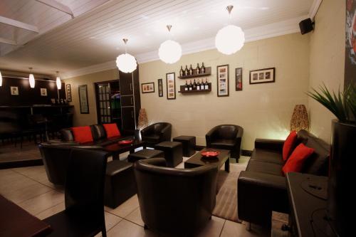 a living room with couches and chairs and a bar at Kakamas Hotel in Kakamas