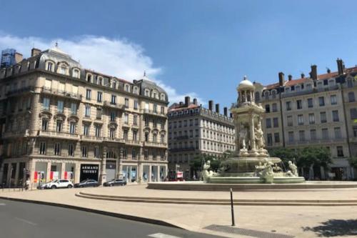 a statue in the middle of a city with buildings at Studio lyonnais calme 4pers Jacobins-Bellecour in Lyon