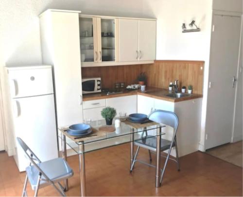 a kitchen with a table and chairs and a refrigerator at Studio lyonnais calme 4pers Jacobins-Bellecour in Lyon