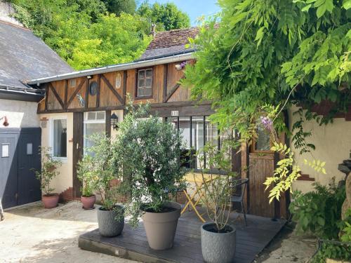 une maison avec des plantes en pot sur une terrasse en bois dans l'établissement Gîte cosy entre Tours et Amboise, à Vernou-sur-Brenne