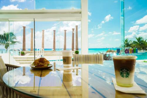 a glass table with food and drinks on a balcony at Krystal Cancun in Cancún