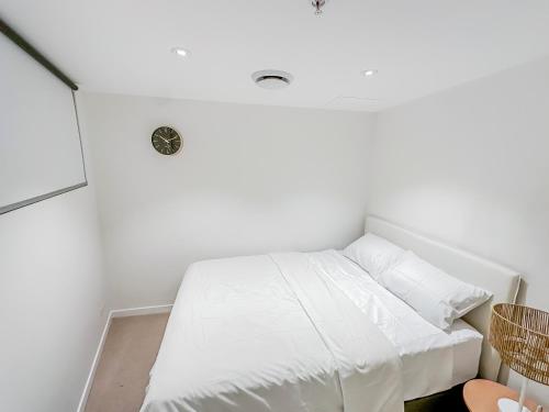 a bed in a room with white walls at Brisbane Skytower By Utopia in Brisbane