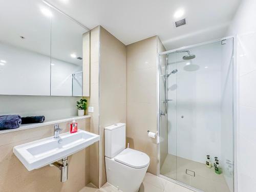 a bathroom with a toilet and a sink and a shower at Brisbane Skytower By Utopia in Brisbane