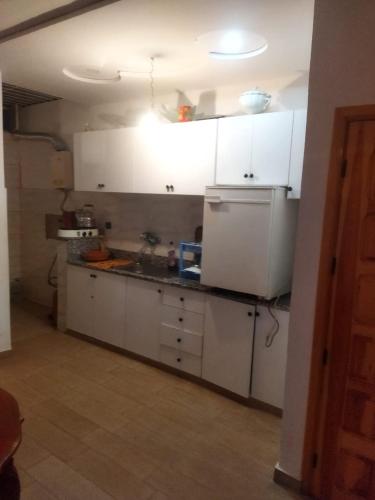 eine Küche mit weißen Schränken und einem weißen Kühlschrank in der Unterkunft Apartamento in Saidia 