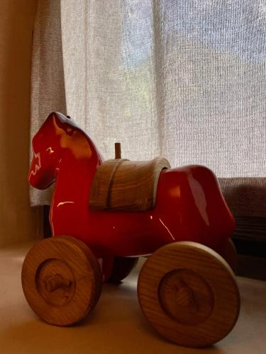 a red toy horse toy sitting on the floor at La Rêverie de Thumel - Suite in Rhêmes-Notre-Dame