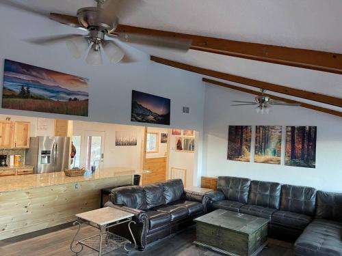 a living room with a leather couch and a kitchen at OVERLOOK LODGE in Banner Elk