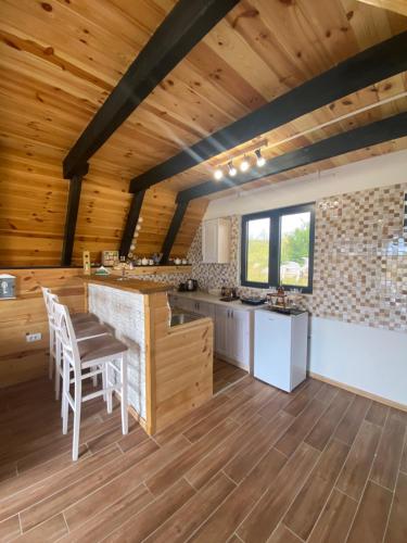 cocina con techos de madera, mesa y sillas en Runolist Chalet, en Žabljak