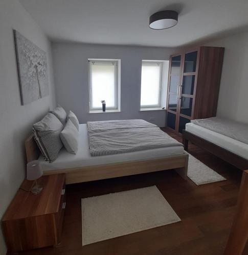 um pequeno quarto com uma cama e 2 janelas em Detmolder Perle em Detmold