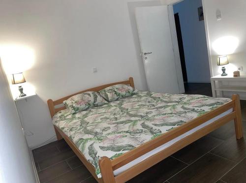 a small bed in a room with two lamps at Apartmani Gacic- Sabac in Šabac