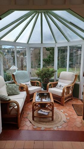 a screened in porch with chairs and a table at Glan Heulog Guest House in Conwy