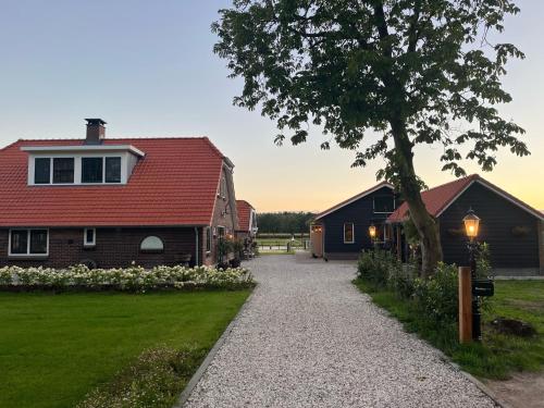 a house with a red roof and a driveway at Bed & Breakfast Hoeve Happiness - ontbijt inbegrepen - wellness aanwezig in Voorthuizen