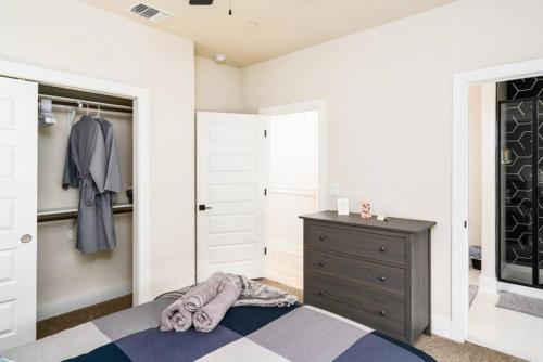 a bedroom with a bed and a dresser and a closet at Spacious New Condo! Near FtSam Houston*Alamo*Pearl in San Antonio