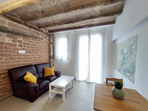 a living room with a couch and a brick wall at Antic Manresa 2 in Manresa