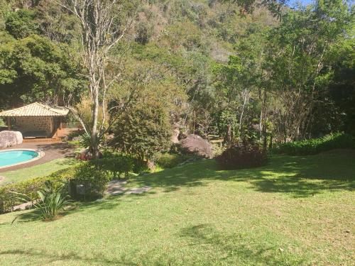 un cortile con piscina e una casa di Casa Riacho Verde a Petrópolis