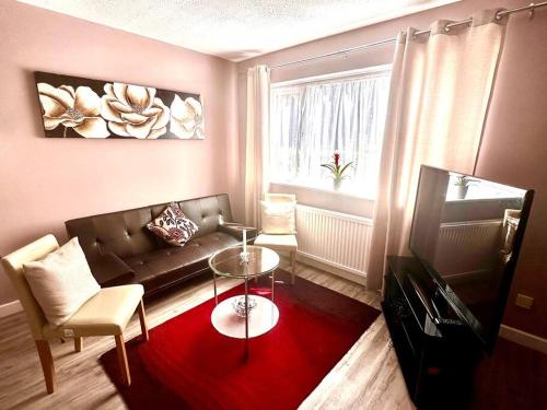 a living room with a couch and a table and a window at NKN cosy maisonette close to train station, food, shopping in Kent