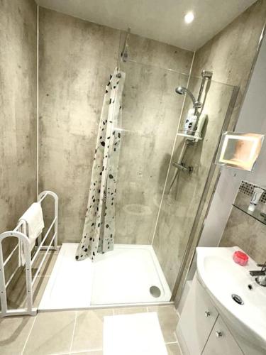 a bathroom with a shower and a sink at NKN cosy maisonette close to Dartford train station, free parking, food, shopping in Kent